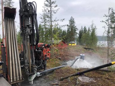 Brønnboring ved innsjø i skog