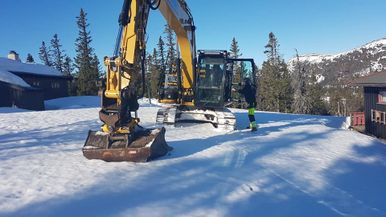 Gravemaskin arbeider i snø