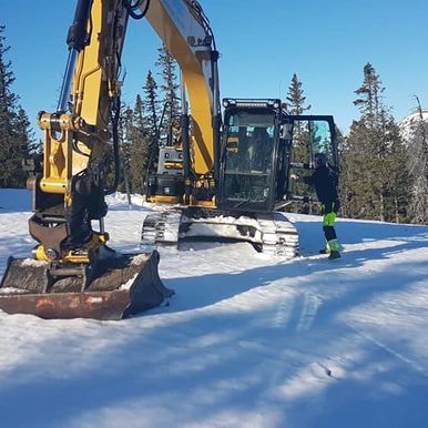 Gravemaskin arbeider i snø